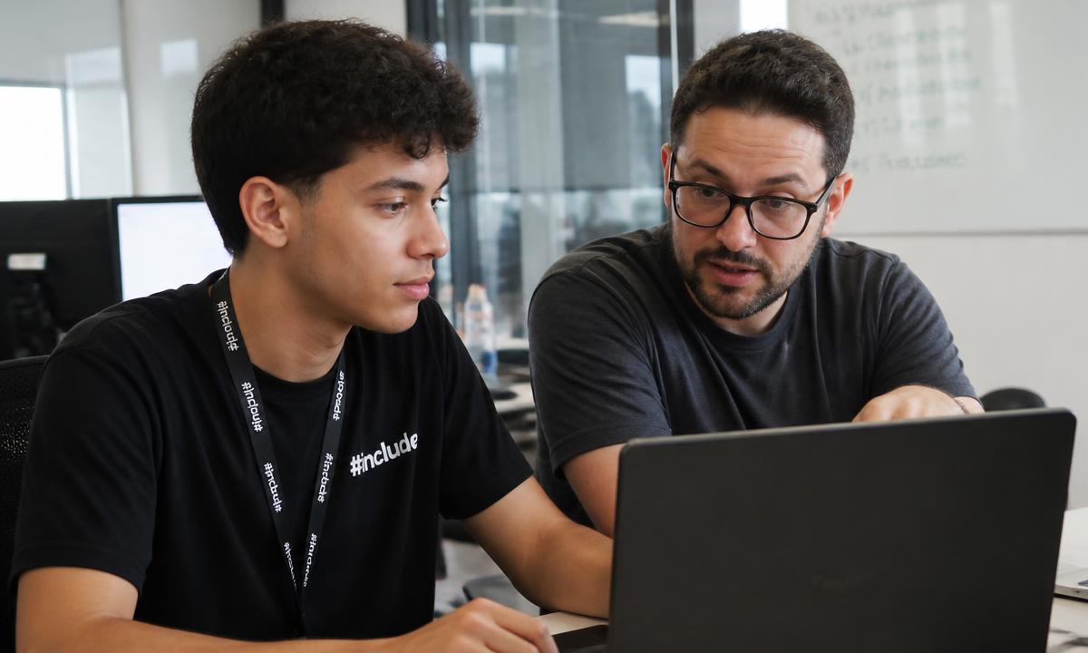 Jovem acompanhando um profissional no escritório, olhando a tela junto